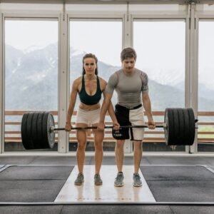 mFit man and woman lifting a barbel with a lot of weight