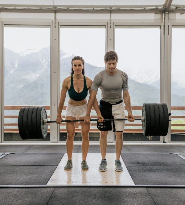 mFit man and woman lifting a barbel with a lot of weight